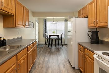 A kitchen with wooden cabinets and a white refrigerator.